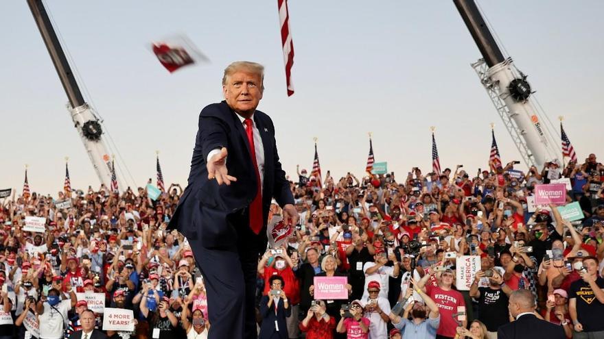 Trump lanza una mascarilla durante un mitin de campaña.