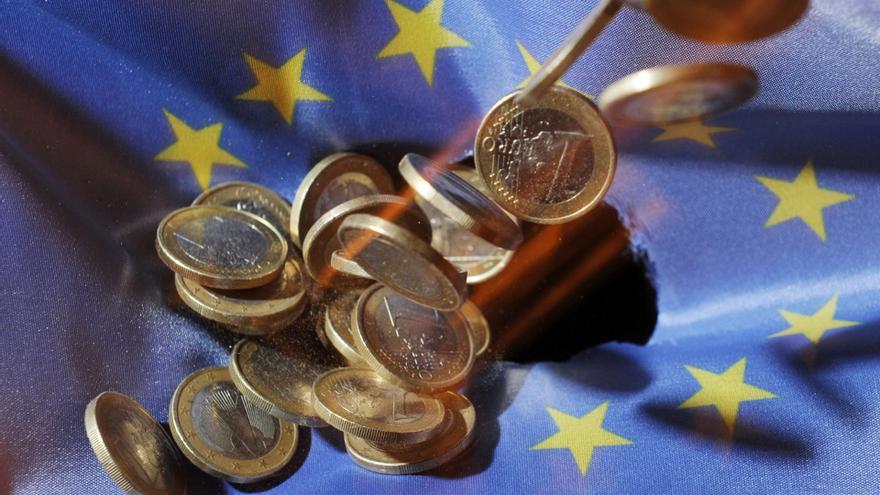 Archivo - FILED - 04 July 2011, Baden-Wuerttemberg, Karlsruhe: One euro coins will fall onto an EU flag. The European Union's gross domestic product shrank 3.5 per cent in the first three months of the year, according to a first estimate from Eurostat, wh