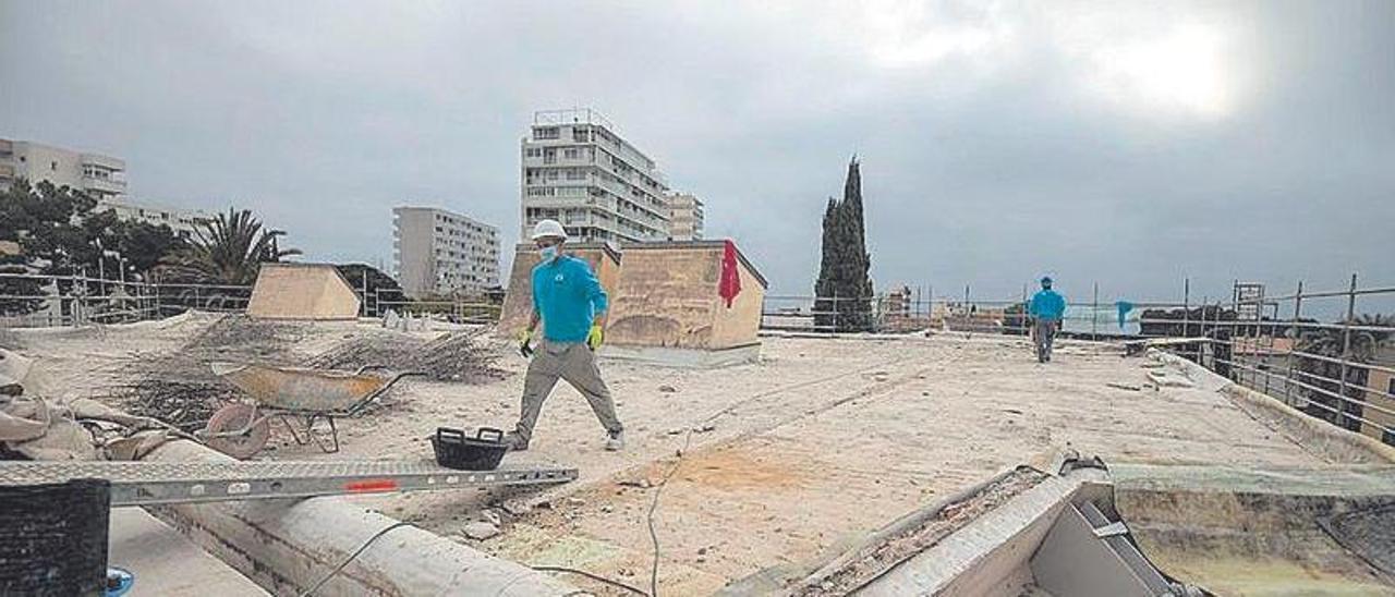 Dos obreros trabajando en la cubierta del edificio situado en Cala Major.