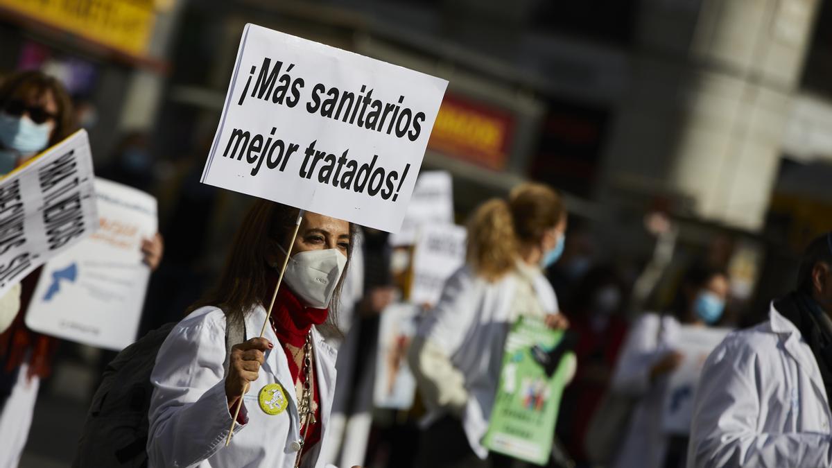 Archivo - Una trabajadora sanitaria sostiene un cartel donde se puede leer &quot;Más sanitarios mejor tratados&quot; durante una concentración convocada por la Asociación de Médicos y Titulados Superiores de Madrid (AMYTS), en la Puerta del Sol, en Madrid (España),