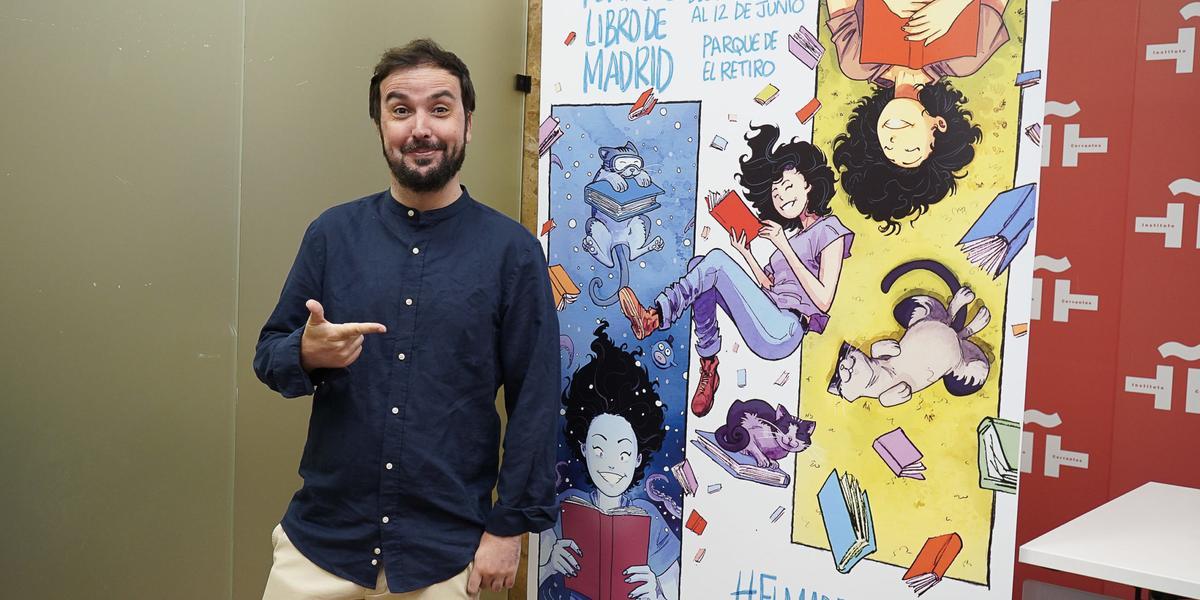 Isaac Sánchez junto al cartel de la Feria del Libro de Madrid 2022 diseñado por él mismo