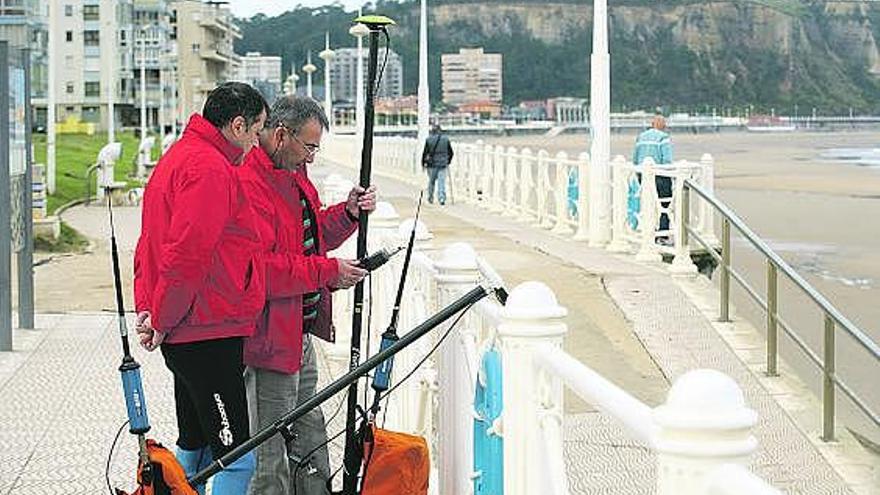 Los topógrafos del Cedex Santos Gutiérrez y José Losada, preparando el equipo para realizar mediciones en la playa.