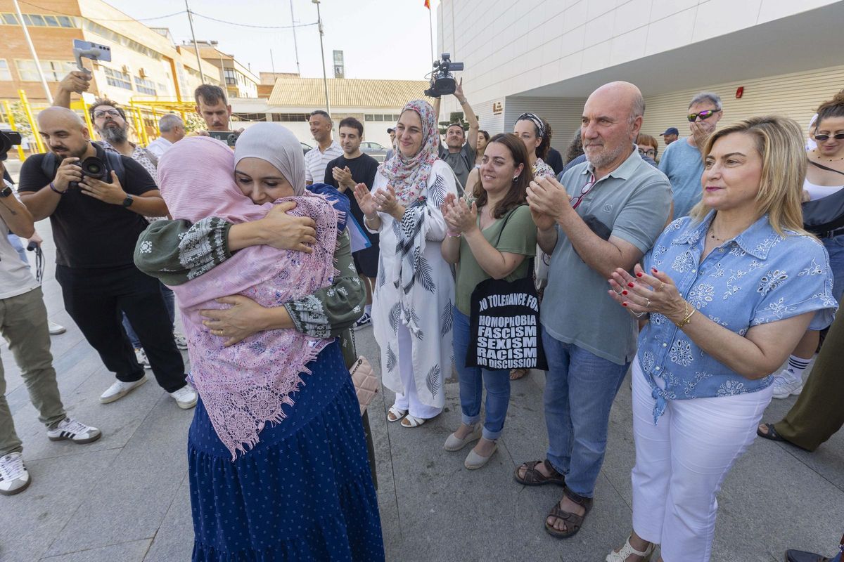 Carmina Fernández (d), junto a José Luis Álvarez-Castellanos y Penélope Luna, de IU, observan a dos vecinas de Torre Pacheco dándose un abrazo tras la lectura del manifiesto.