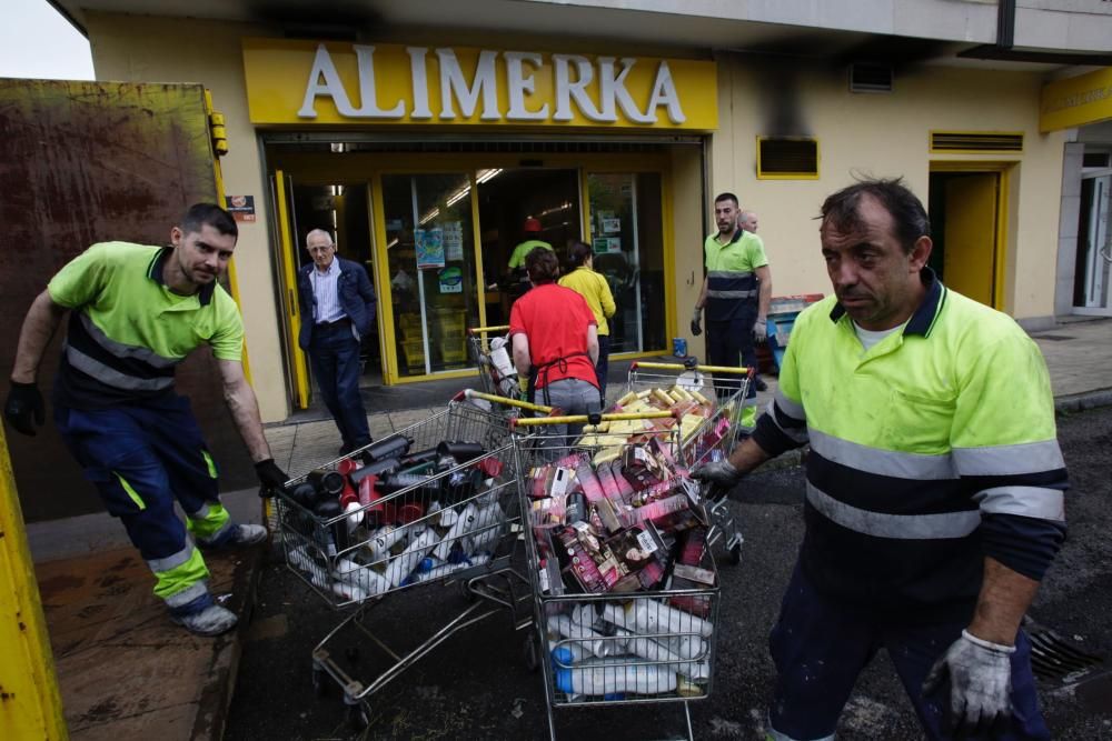 Labores de limpieza tras el incendio en un supermercado de La Tenderina.