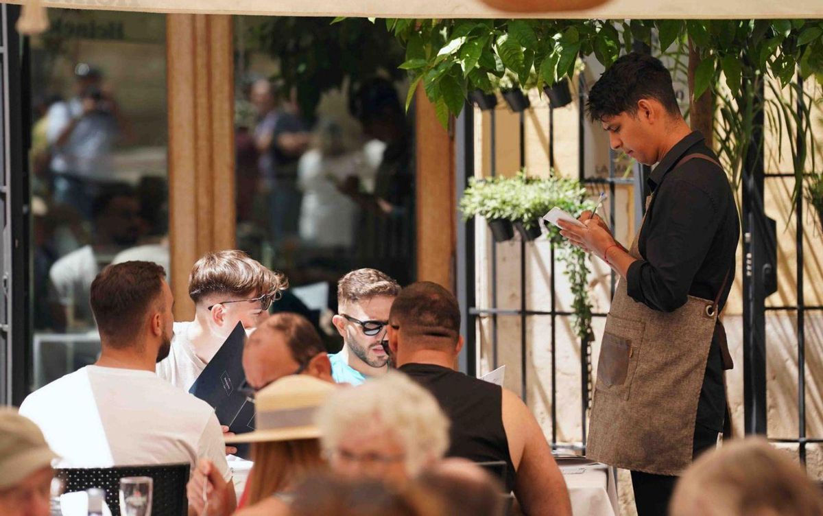 Un camarero atienda a los clientes en la terraza de un restaurante de Málaga. | ÁLEX ZEA