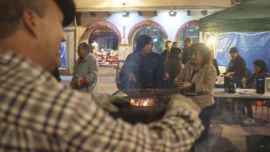 Miembros de la Asociación de Familias Numerosas preparando y asando castañas.