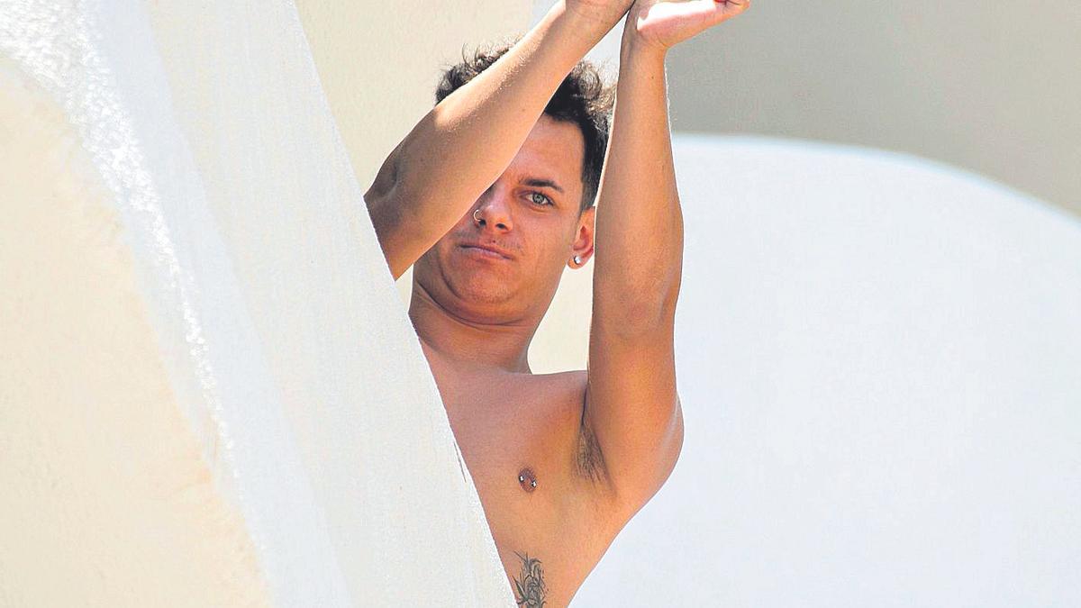 Un joven hace un gesto de estar esposado en un hotel de Mallorca, reconvertido para que más de 300 pasen la cuarentena