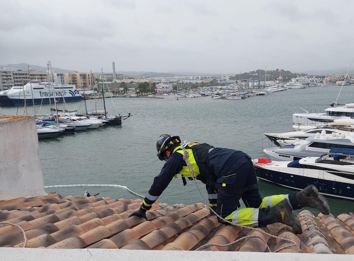 Un efectivo de los bomberos subida al tejado de la Marina afectado por el mal tiempo