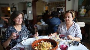 Dos clientas, frente a un plato de cocido, una de las especialidades del restaurante del Hogar Extremeño, en plena Gran Vía.