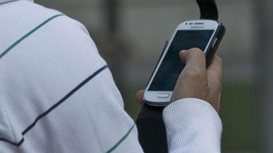 Un joven utiliza un smatphone.