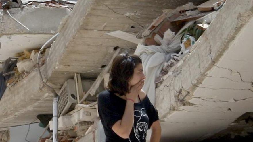 Una joven pasa ante los escombros provocados por el terremoto de Lorca.