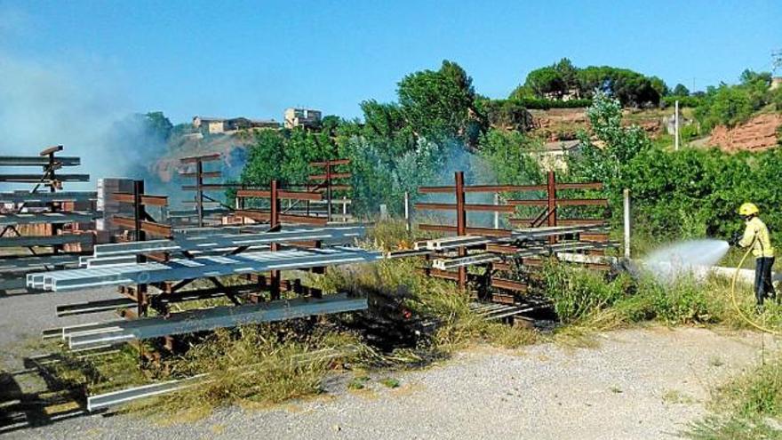 Un bomber ruixant un foc ahir a la tarda a Sant Joan de Vilatorrada