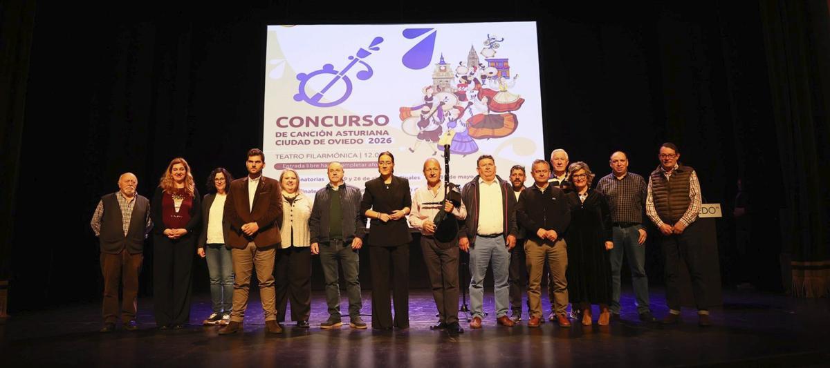 Sobre el escenario del Filarmónica, por la izquierda, José Luis Sánchez Verdeja, Mónica Vega Ramos, Piedad García Guerra, Esteban Verdeja Martínez, Lorena Corripio López, Manuel Arenas Pérez, la concejala Covadonga Díaz Álvarez, el gaitero oficial del concurso, Vicente Prado, «El Pravianu», Carlos Mier Mier, Odón García González, «Odón del Paganéu», Rogelio Mier Mier, Manuel Sañudo Sainz, la presentadora Almudena Iglesias, Marcelino Fernández García y el director del certamen, Laude Martínez.