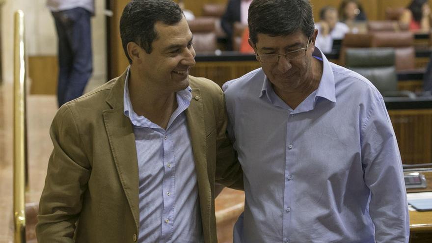 La imagen muestra a Juanma Moreno y Juan Marín durante una conversación captada en el Parlamento.