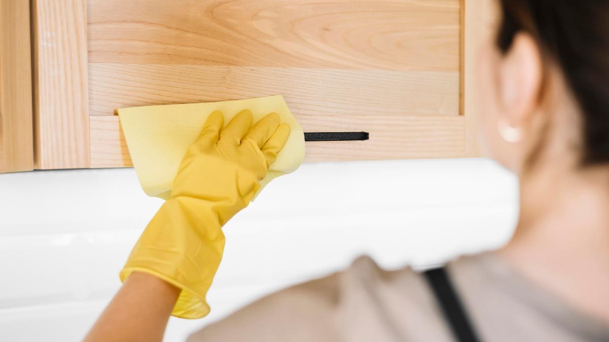 Una persona limpia los muebles de madera en un hogar