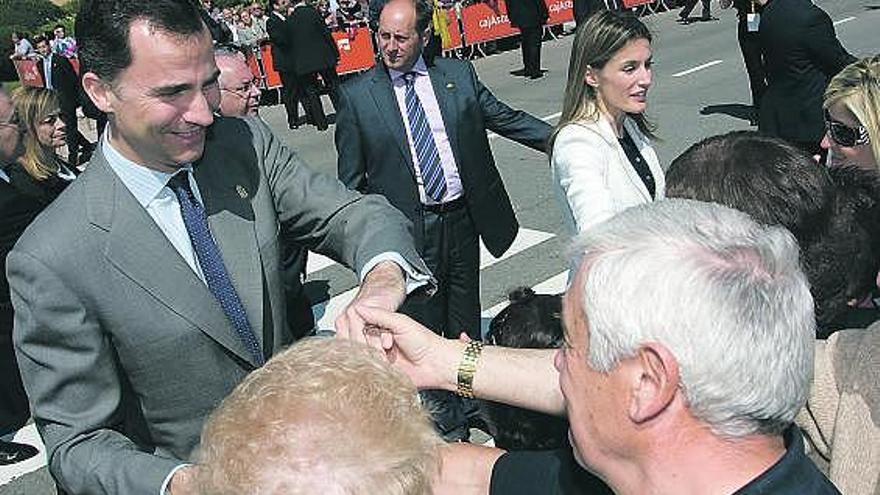 Los Príncipes estrechan la mano de unos vecinos, ayer, en la plaza de Europa.
