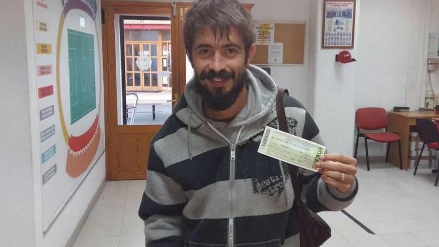 Un aficionado posa con la primera entrada vendida para el derbi entre el Mallorca y el Baleares.