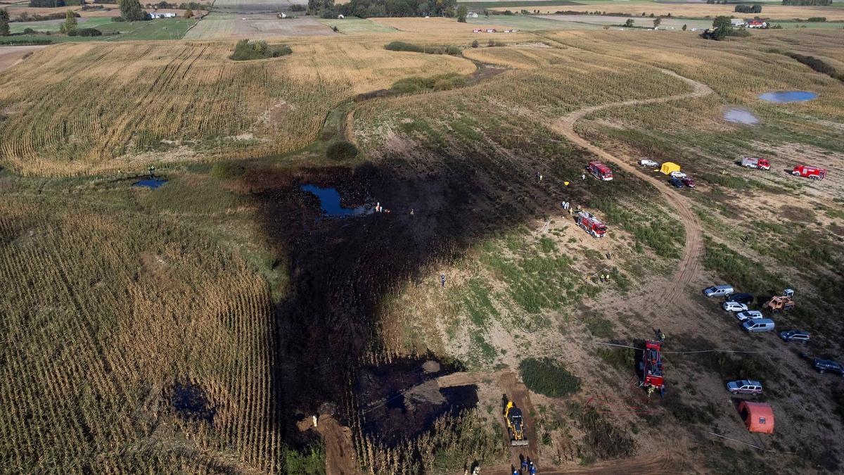 Firefighters work in the field near the Druzhba pipeline where an oil leak was detected