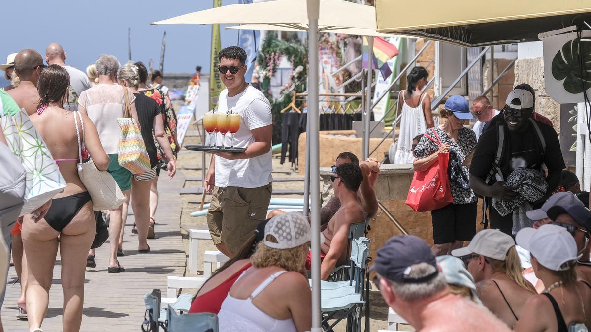Un camarero sirve bebidas a turistas en un local en el sur de Gran Canaria.