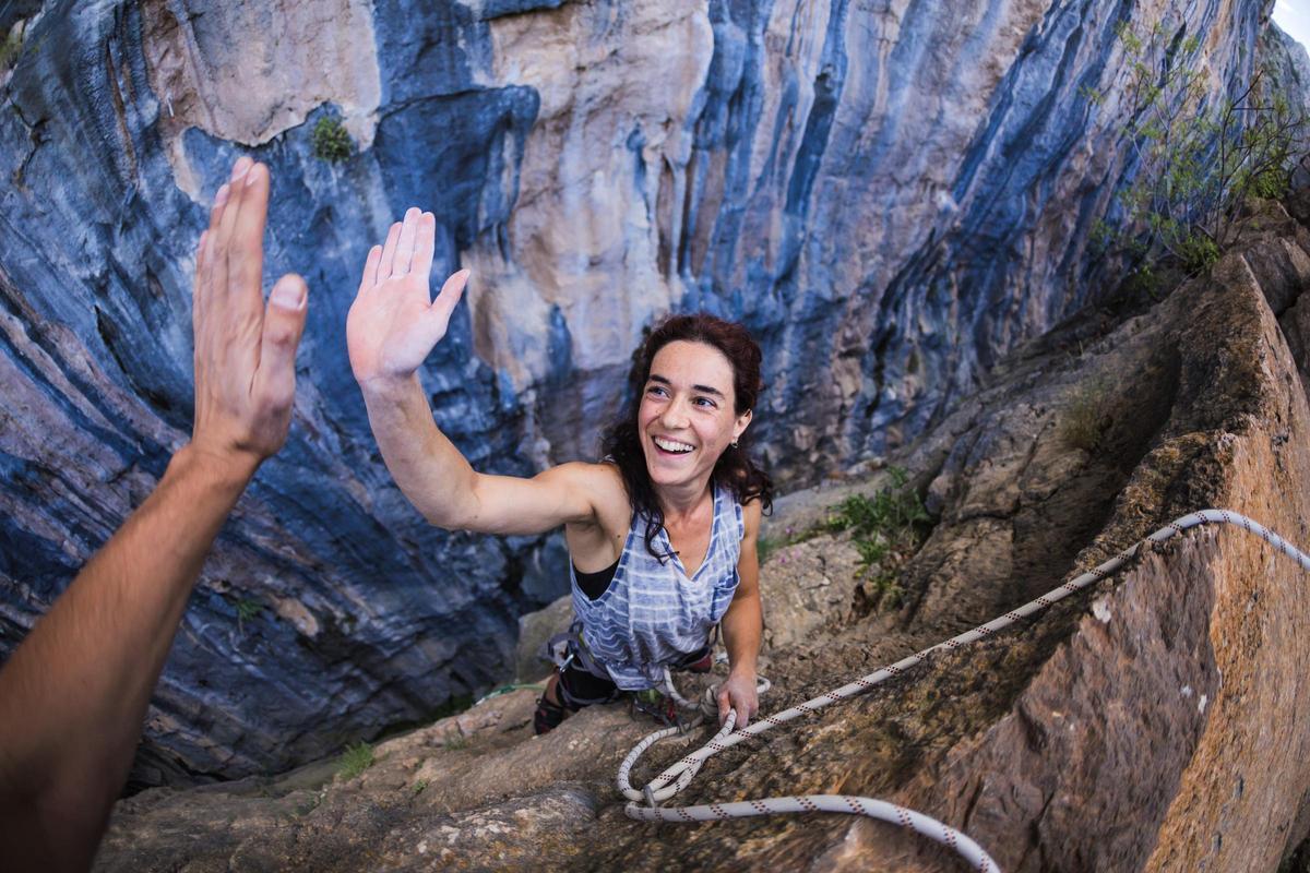 Escaladora disfrutando tras completar una ascensión. Foto: Shutterstock