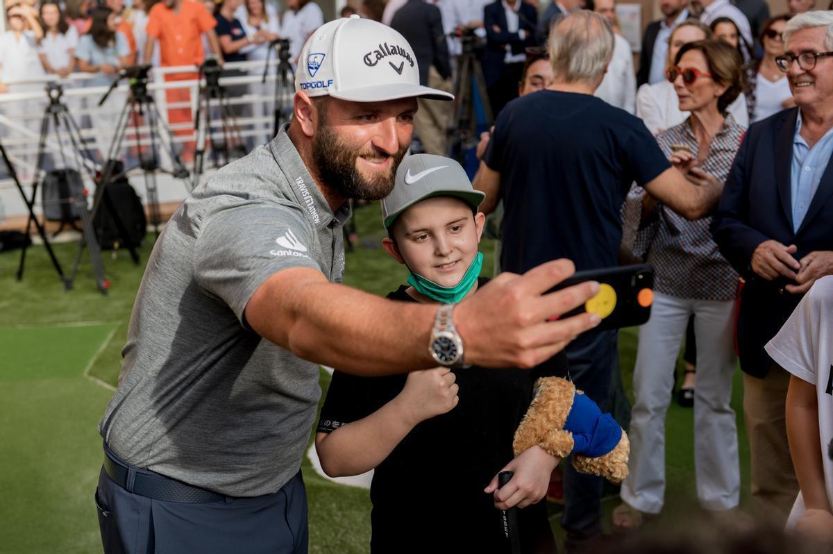 El golfista Jon Rahm con uno de los niños del hospital.