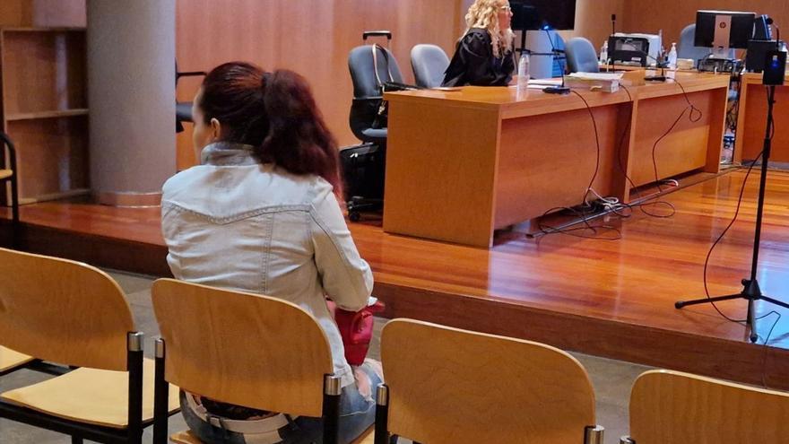 La acusada, de espaldas, con su abogada, Rebeca Vijande, al fondo, ayer, durante el juicio celebrado en la Sección Segunda de la Audiencia Provincial. | LNE
