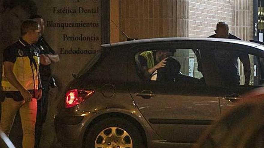 Varios agentes preparan la salida de la mujer detenida del portal donde residía junto a su marido.