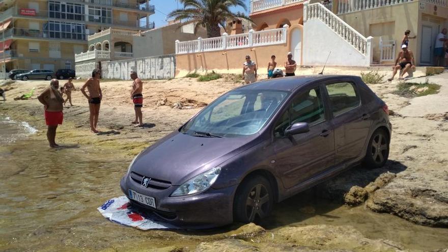 Un coche cae a la orilla del mar en la playa de Los Náufragos de Torrevieja