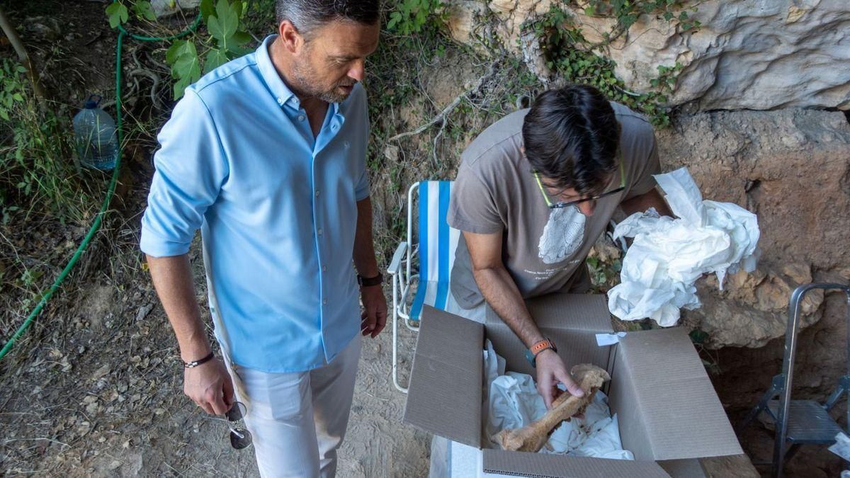 Investigadores con un hueso descubierto en la Cueva Negra de Caravaca.