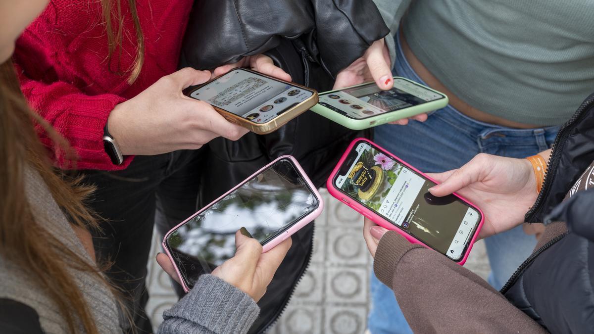 Jóvenes atentas a las pantallas de sus móviles