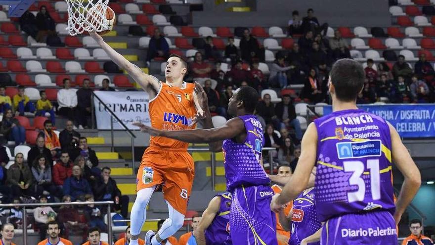 Zach Monaghan entra a canasta por encima de Mamadou Samb, pívot del Palencia, en el partido disputado anoche en el Palacio.