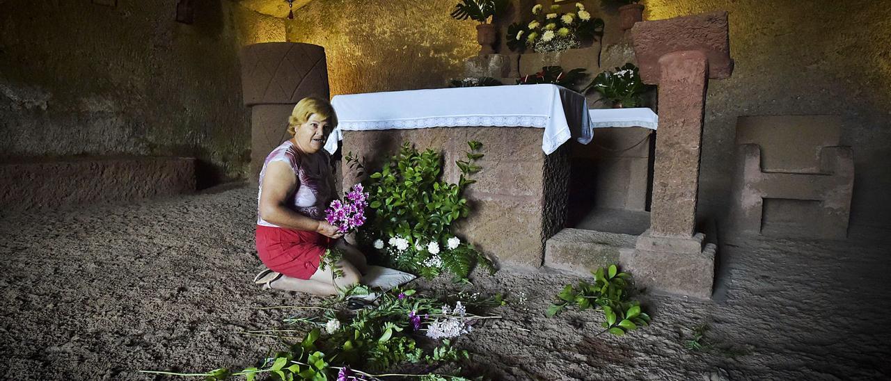 La camarera de la Virgen de la Cuevita, Mari Suárez, prepara el regreso de la patrona, hoy lunes, en la ermita horadada y labrada en el siglo XVIII. | | ANDRÉS CRUZ