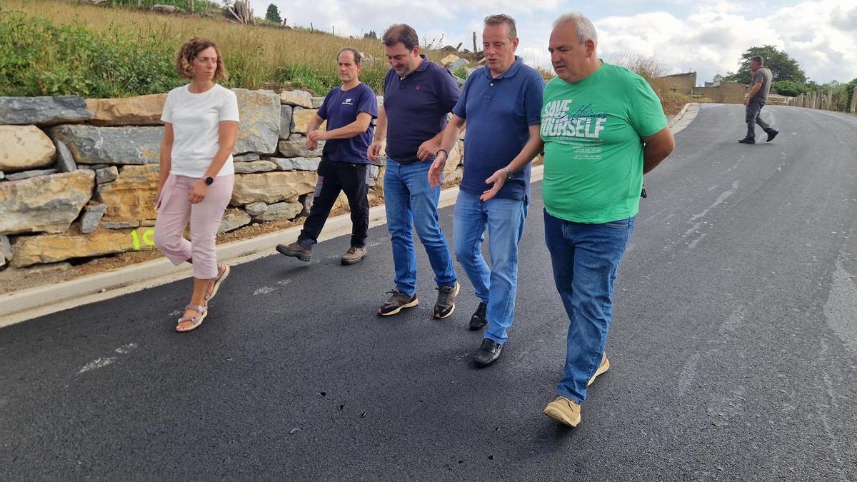 El consejero de Medio Rural, Marcelino Marcos, y el alcalde de Salas, Sergio Hidalgo, caminan en el medio con dos vecinos y la concejala de Salas, Ángeles Fernández.