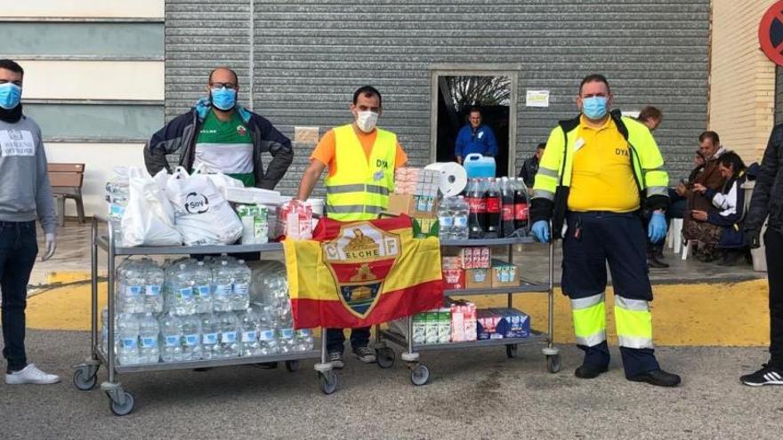 Los componentes de la Grada de Animación y Jove Elx entregando agua, zumos y leche a los voluntarios de DYA