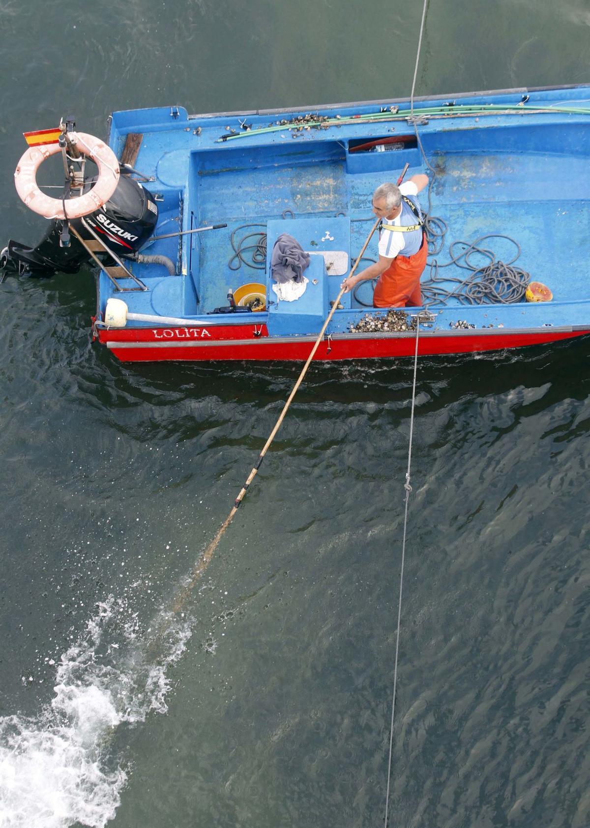 Un tripulante, largando su raño en la campaña de libre marisqueo. |   //  NOÉ PARGA