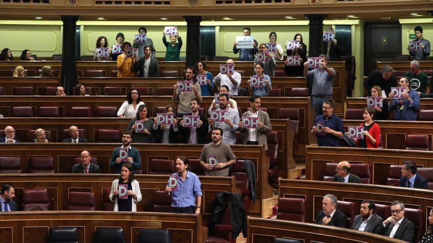 Diputados de Podemos exhiben carteles contra los CIE en el pleno del Congreso