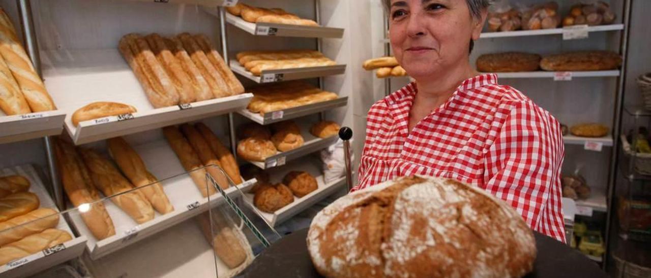 Margarita Rodríguez, con una hogaza del pan &quot;más sano del mundo&quot; tras el mostrador de su negocio, ubicado en la calle Fernando Morán.