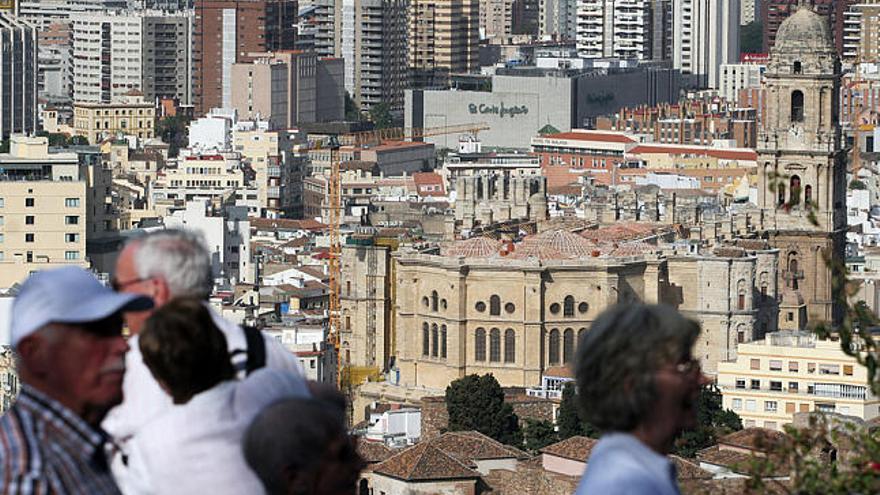 Málaga. Varios turistas visitan el parador de Gibralfaro con la torre de la Catedral al fondo.