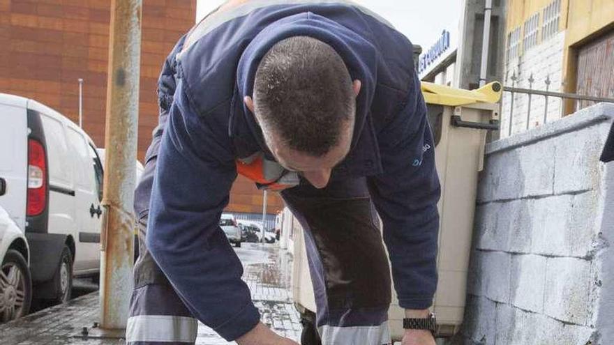 Un operario trata de arreglar una boca de riego.