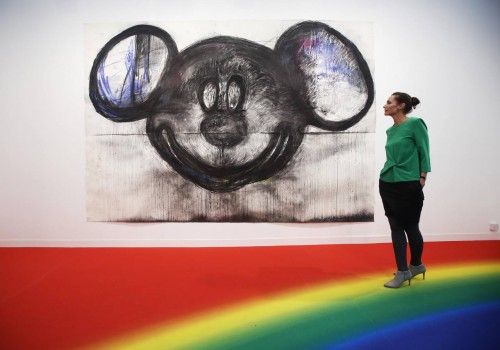 Un visitante posa con las ilustraciones del artista Joyce Pensato "Mickey para Micky" en la Feria de Arte Frieze en Londres