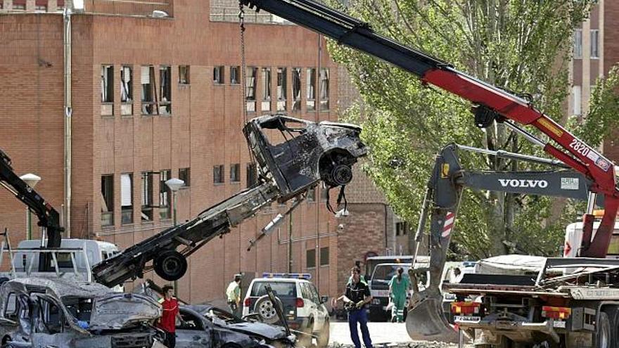 Varias grúas trabajaban ayer llevándose los vehículos destrozados que dejó el coche bomba y limpiando la zona, mientras los peritos evaluaban los daños