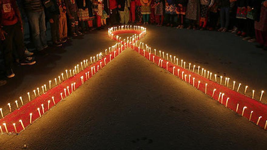 Mujeres y niños seropositivos de Nepal forman un lazo rojo.