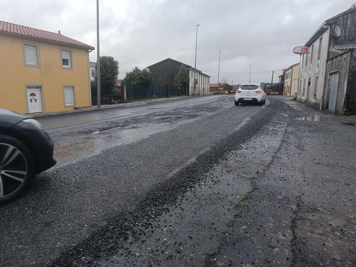 Coches avanzando hacia el arcén en la aldea de Oroso ante el calado de un macrobache de la N-550