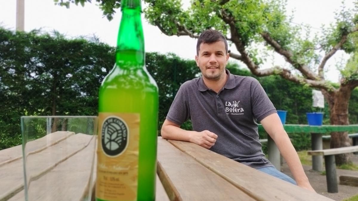 Rubén Campa Solís con una botella y vaso de sidra.