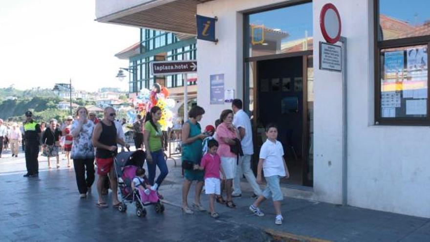 Visitantes en Luanco durante el presente verano paseando ante la oficina de turismo de Luanco.