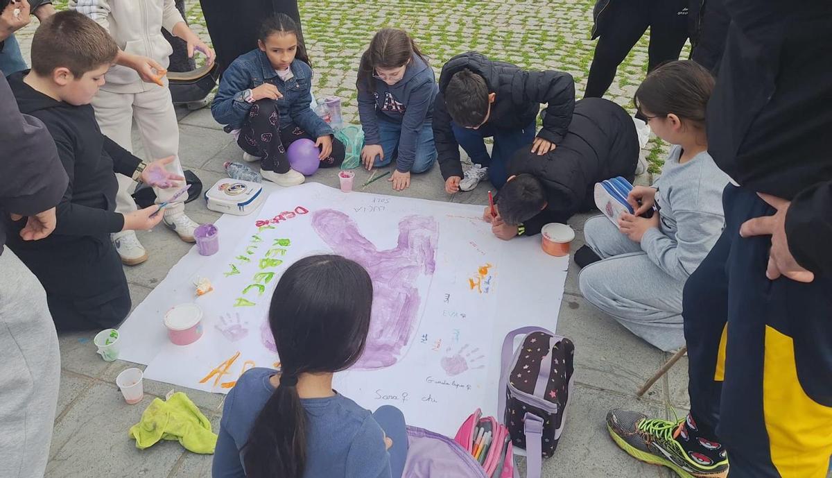 FOTOS | Alumnos de los colegios Cerro de Reyes y Pastor Sito pintan de violeta el barrio por el 8M
