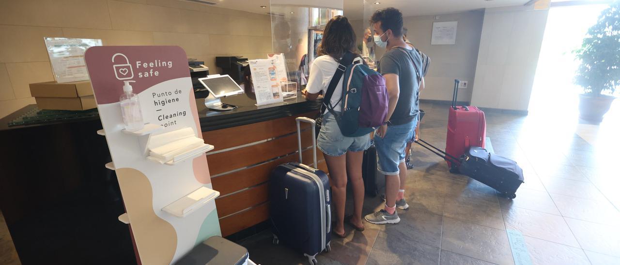 Unos clientes realizan el ‘check in’ a su llegada al hotel Orange de Benicàssim.