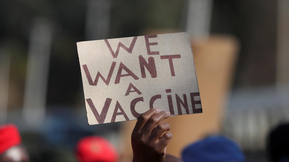 Una persona amb un cartell que reclama accés a les vacunes contra la covid-19, a Pretòria, Sud-àfrica.