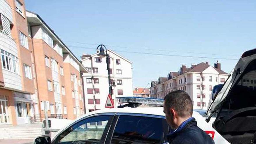 El alcalde, Iván Fernández, junto a un coche de la Policía Local.