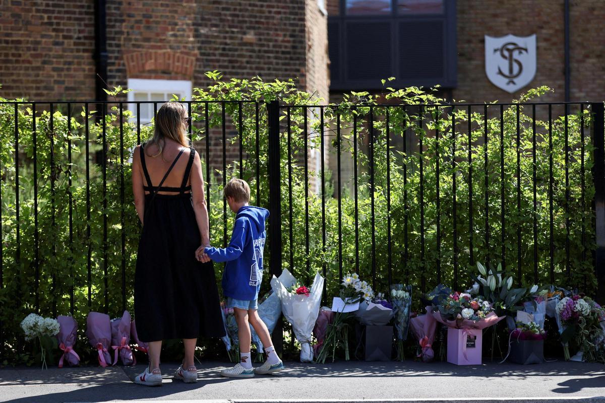 Una madre y su hijo depositan flores a las puertas de una escuela en Wimbledon (Londres), donde se produjo un fatal atropello.